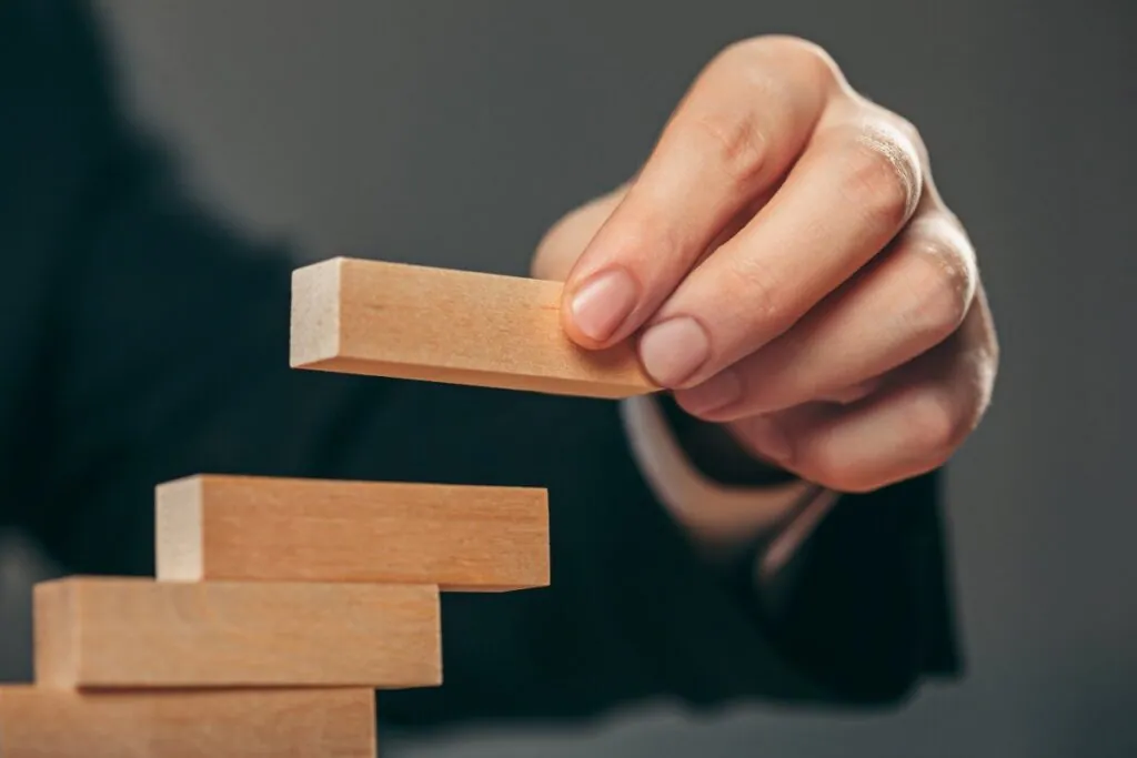 Hand placing wooden block on stack