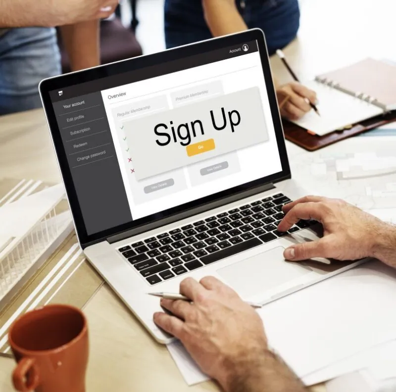 Hands registering on website using laptop