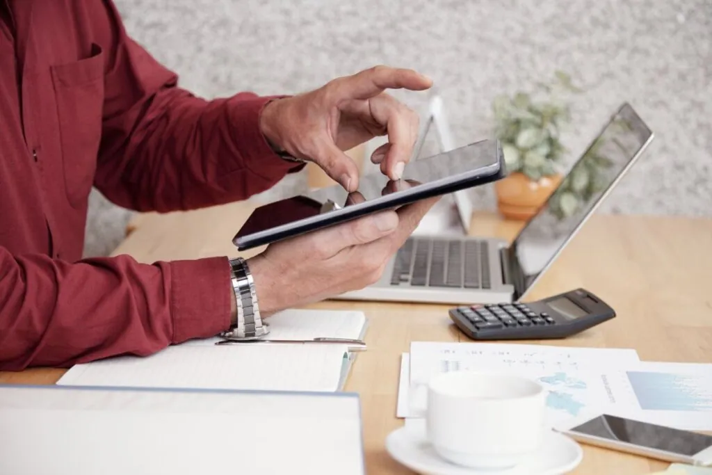 Man using tablet at cluttered office desk