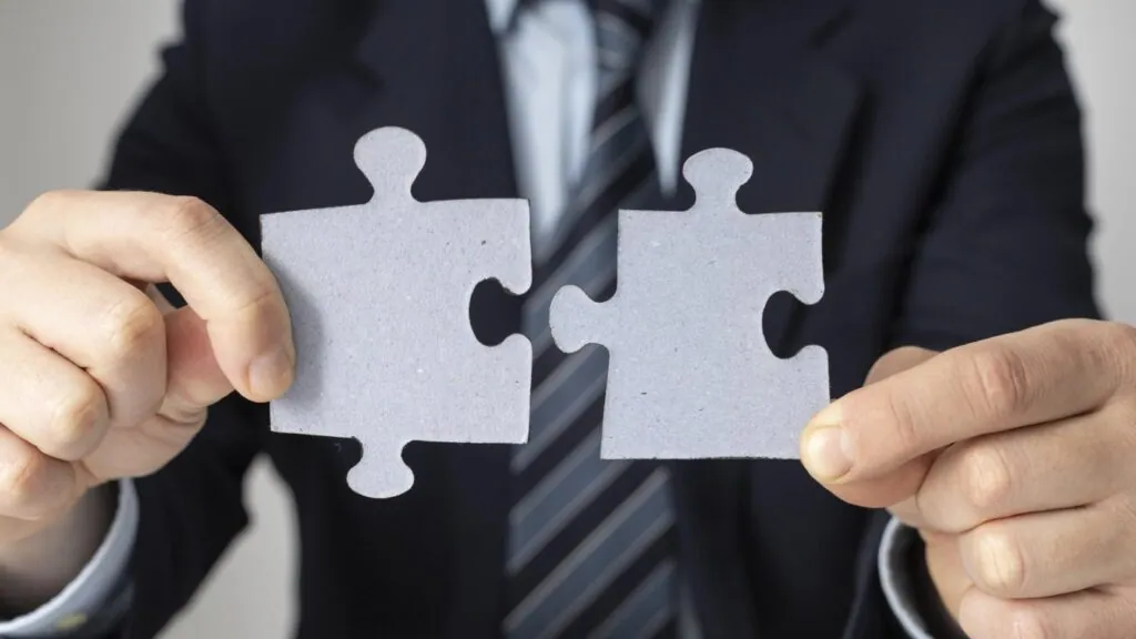 Hands holding connecting puzzle pieces