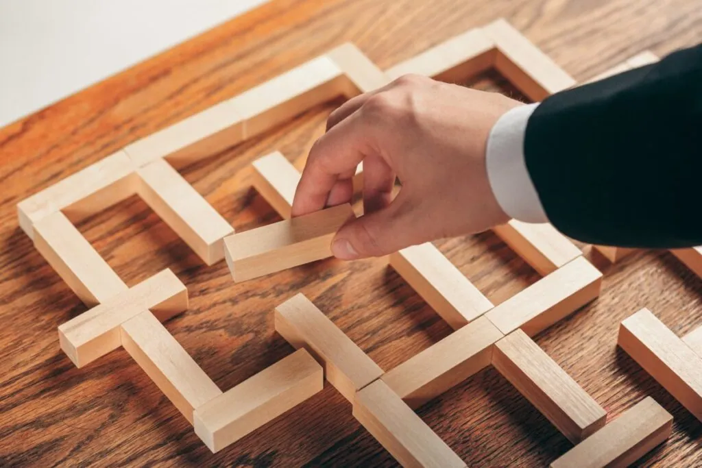 Hand placing wooden blocks in a puzzle formation