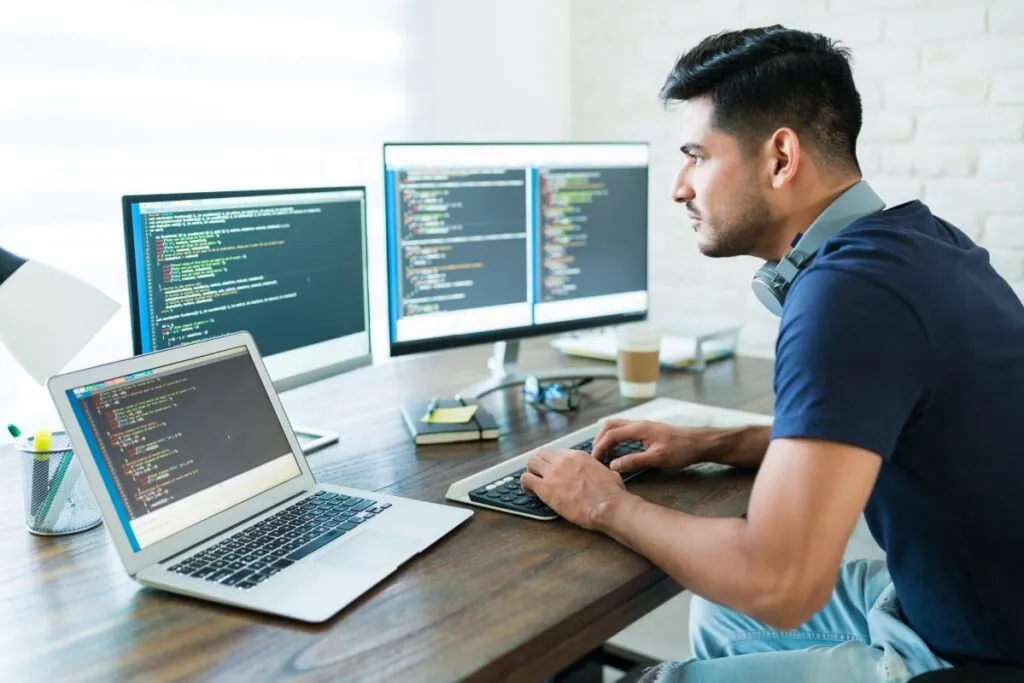Man working on multiple computer screens