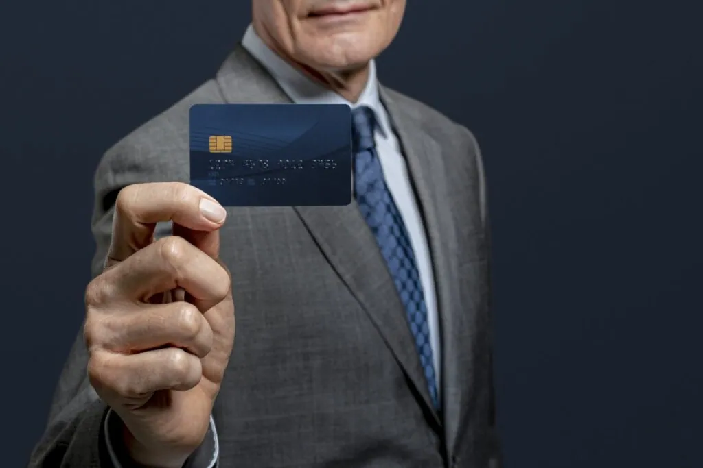 Man in suit holding a blue credit card