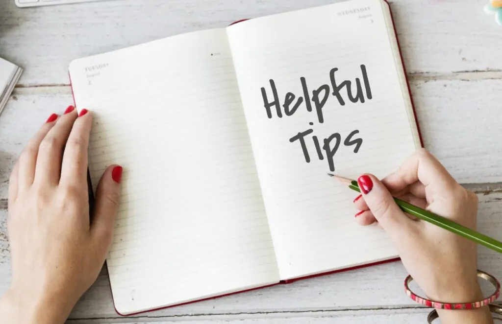 Hands writing "Helpful Tips" in an open notebook