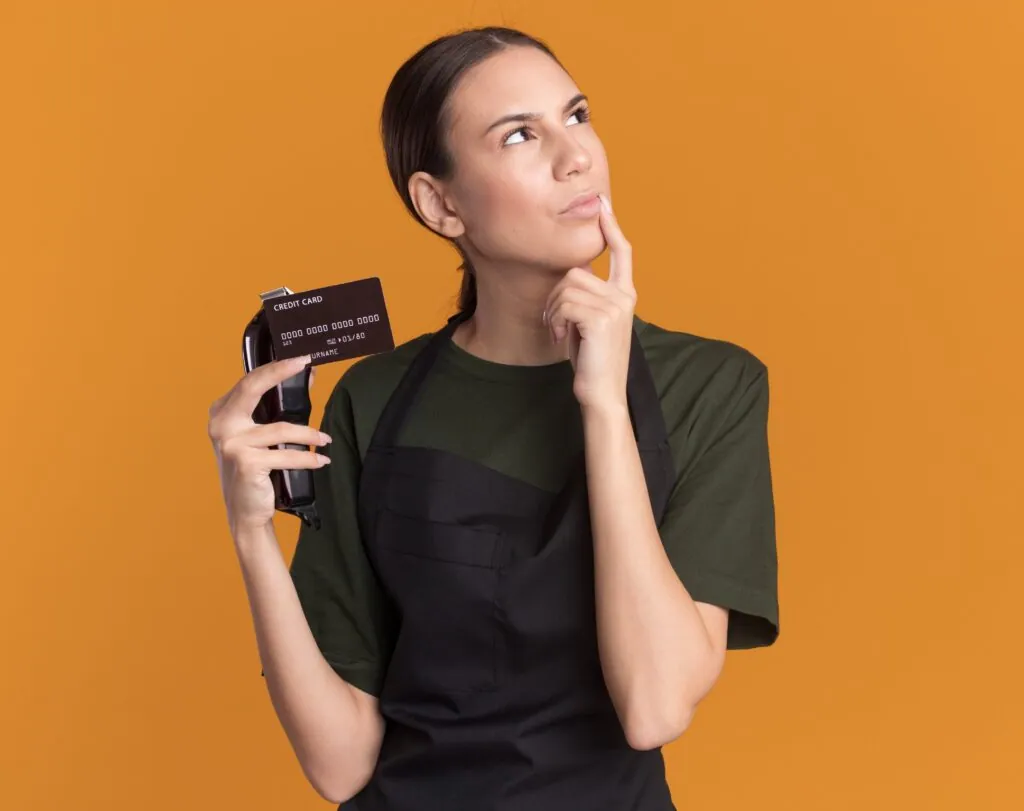 Waitress pondering with credit card and card reader