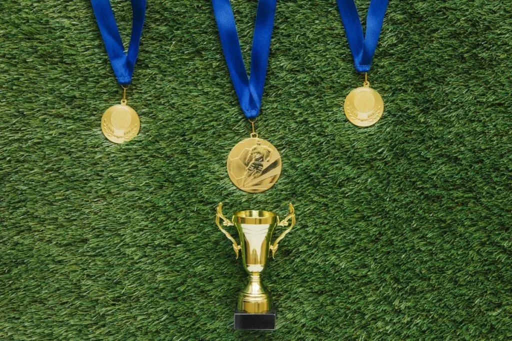 Gold medals and trophy on green turf