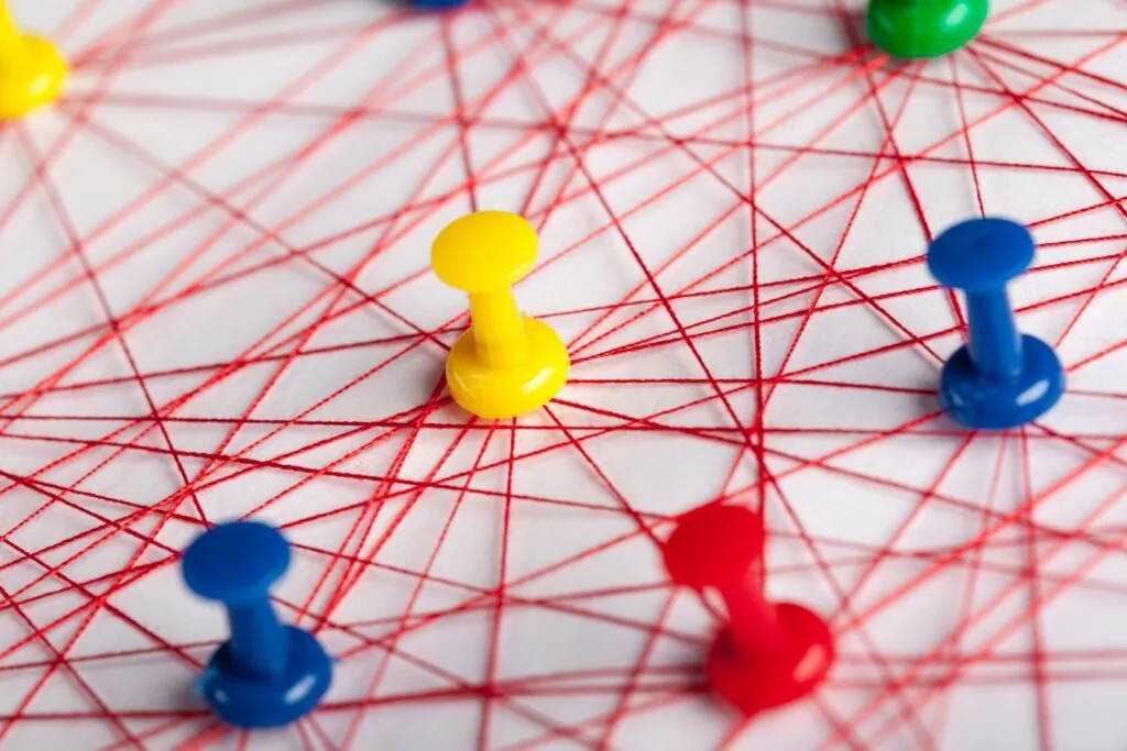 Colorful push pins connected by red string