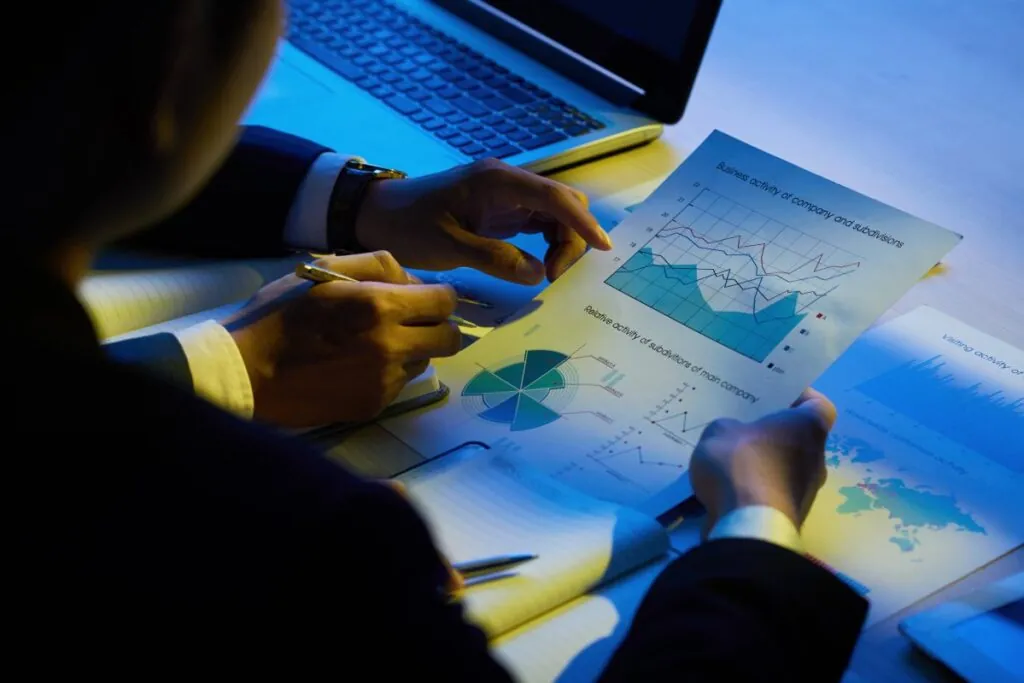 Person analyzing charts and graphs at a desk