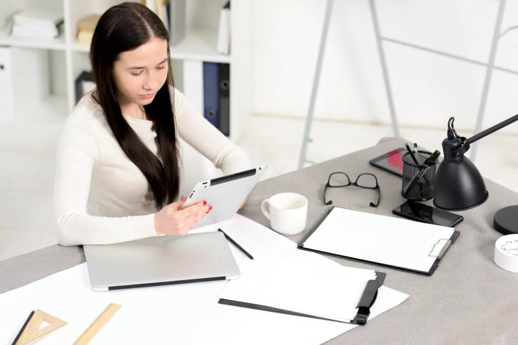 Woman working at desk with a tablet