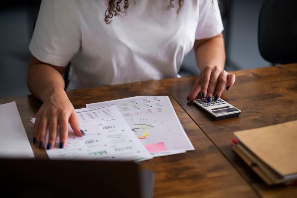 Person using a calculator with documents on the table