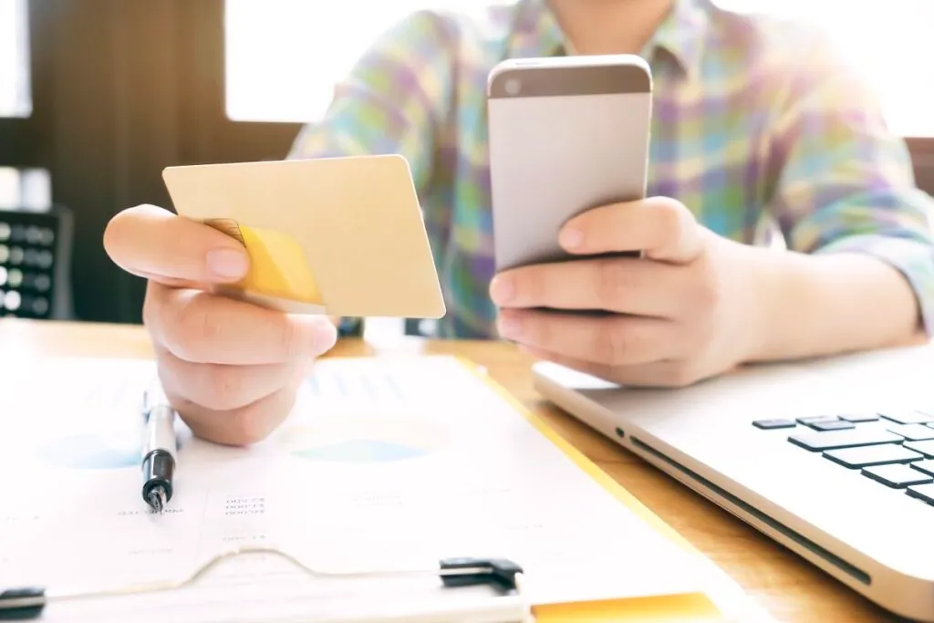 Person holding a credit card and smartphone