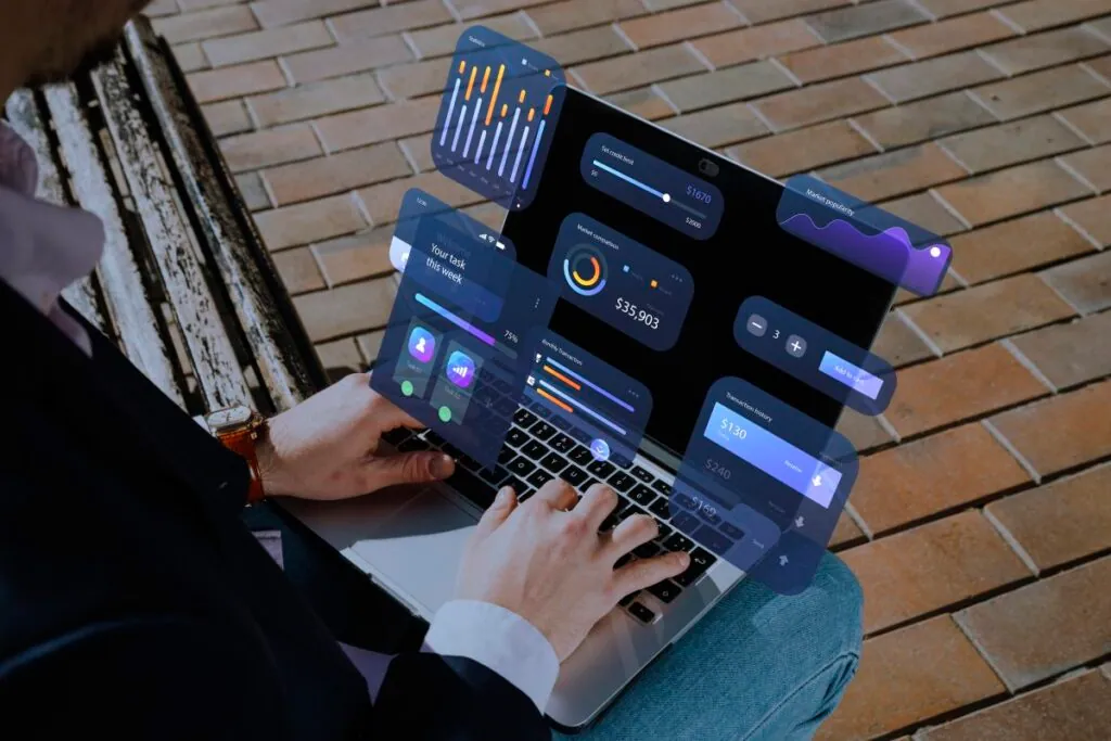 Person using a laptop with digital financial dashboards