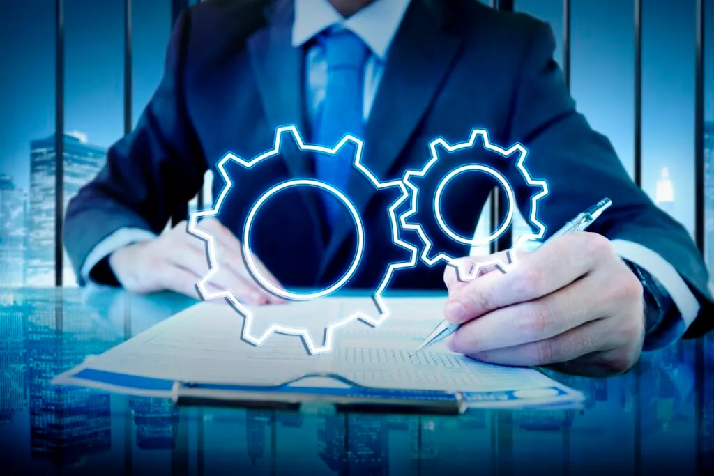 Businessman with gears hologram writing on paper