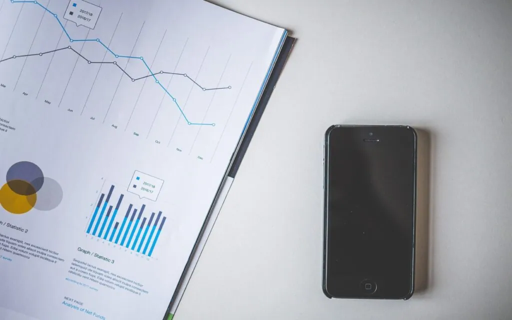 Smartphone beside a paper with charts