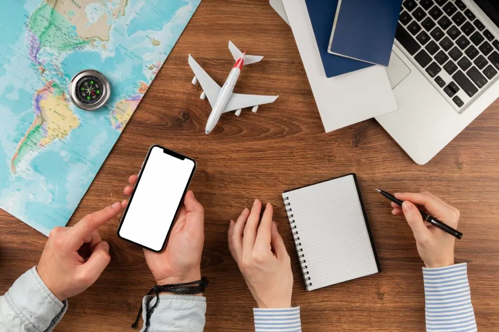 Hands planning a trip with map phone and notebook