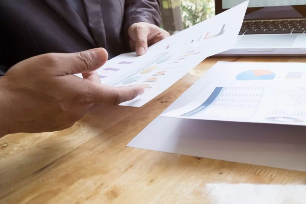Person reviewing documents with charts and graphs