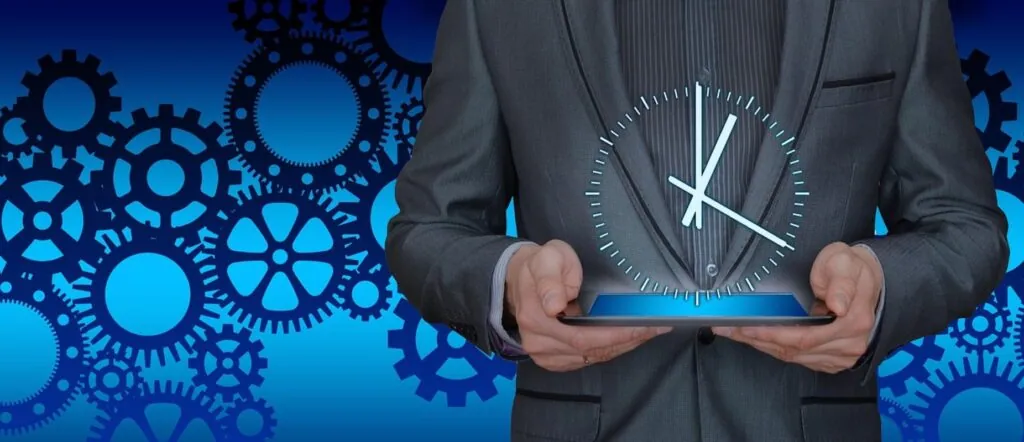 Businessman holding tablet with clock and gears