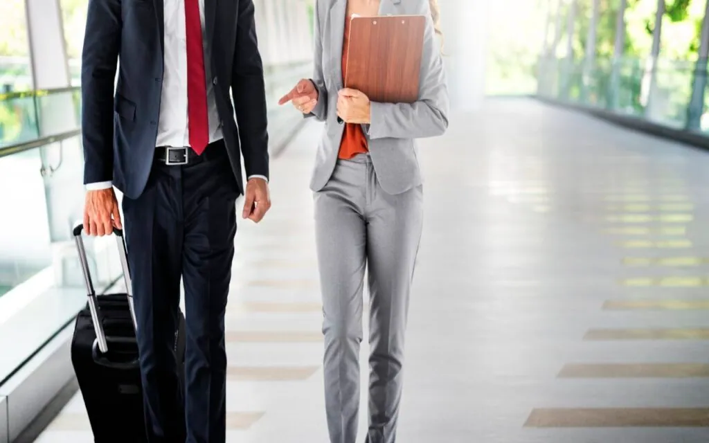 Businesspeople walking and talking with a suitcase