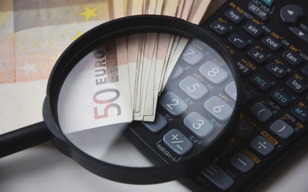 Magnifying glass over Euro notes and calculator