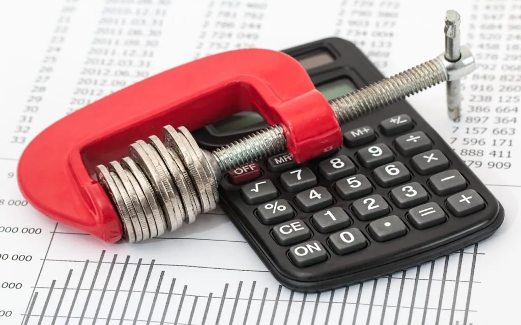 Coins squeezed by clamp on calculator