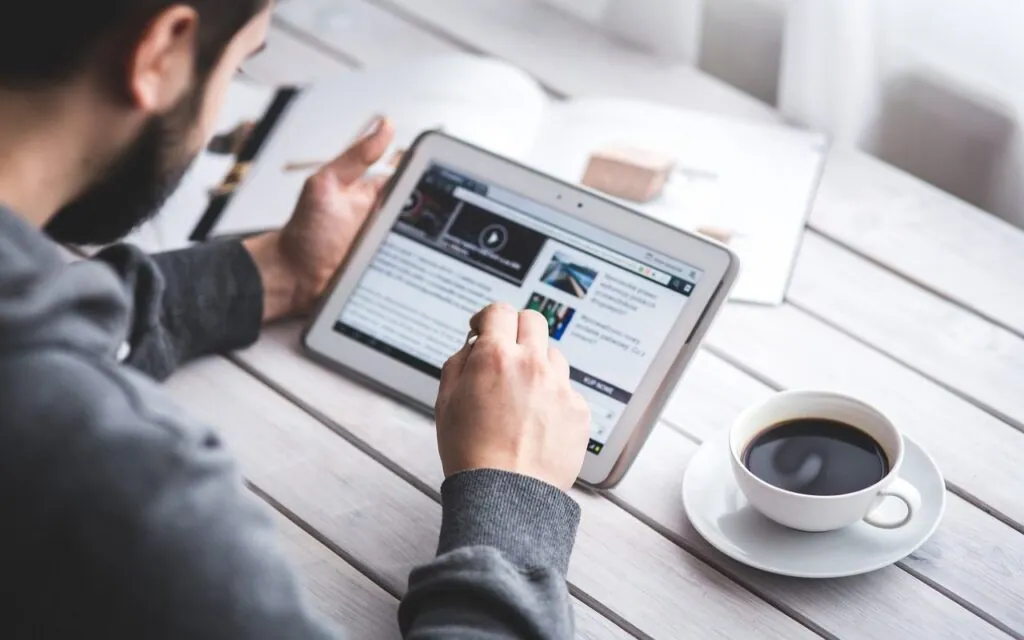 Person reading on a tablet with coffee
