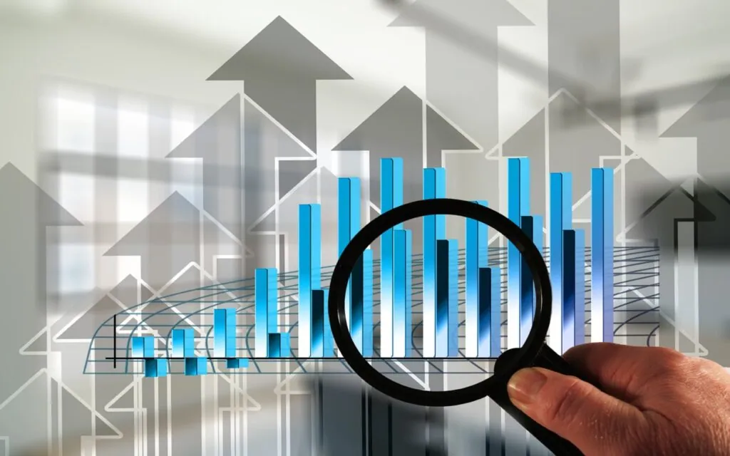 Magnifying glass focusing on a rising bar graph