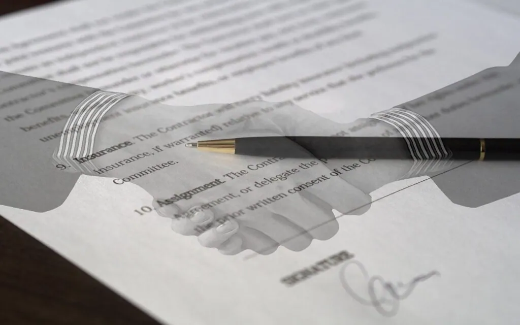 Handshake superimposed on a signed document