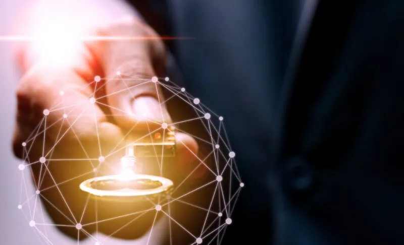 Hand holding a glowing key with network nodes