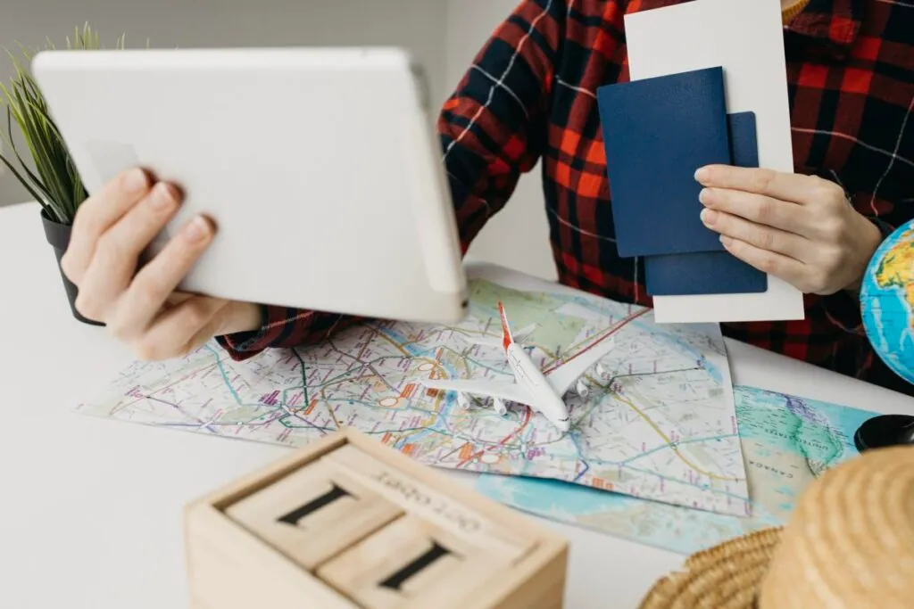 Person planning trip with tablet and map