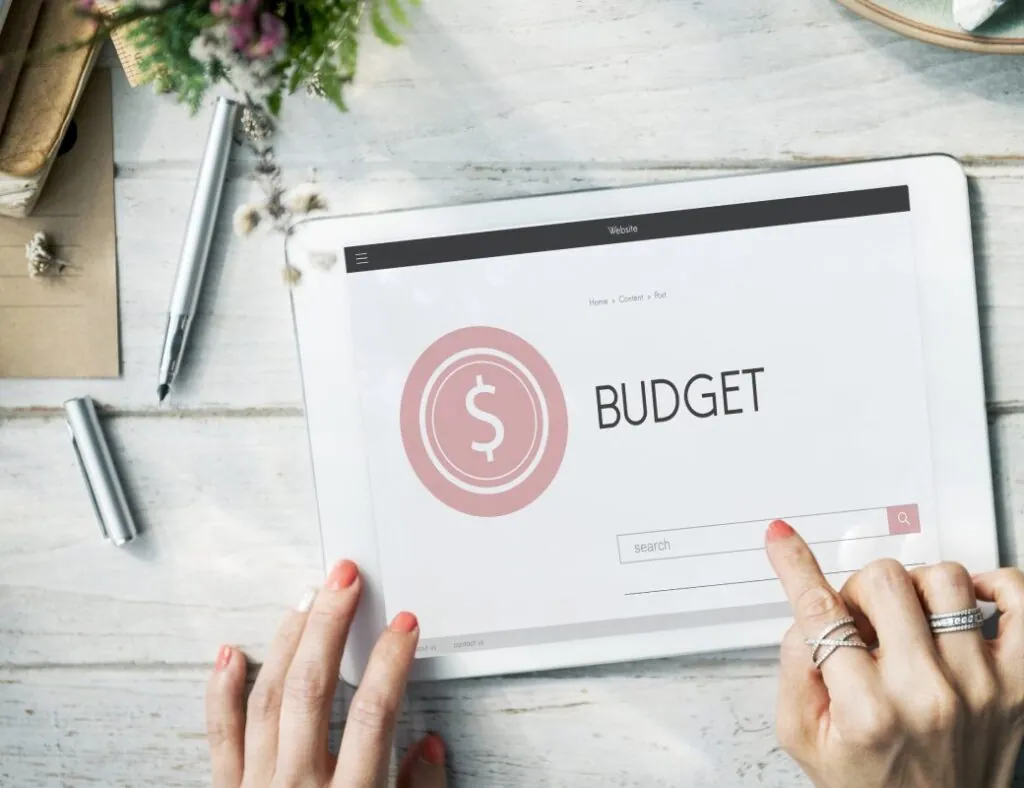 Hands pointing at budget on tablet screen