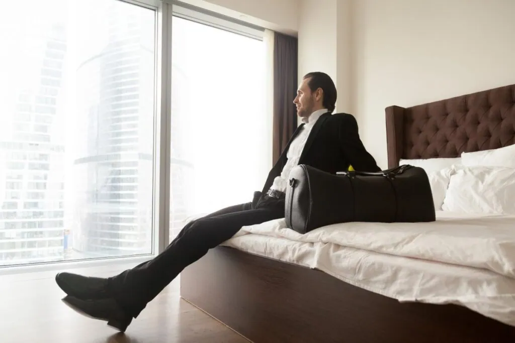 Businessman relaxing in hotel room with city view