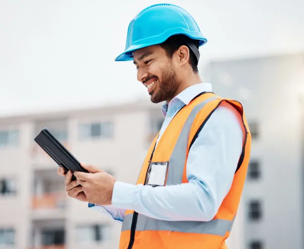 Construction worker reviewing plans on tablet