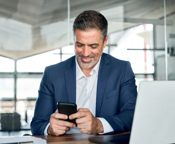 Businessman checking phone at desk