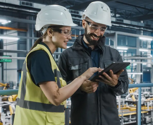 Engineers reviewing factory data on tablet