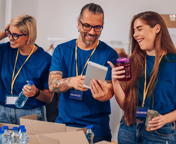 Volunteers organizing donations using tablet