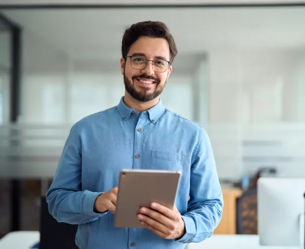 Smiling man in glasses holding a tablet