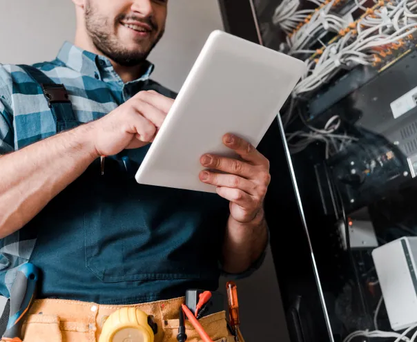 Technician using tablet near server rack