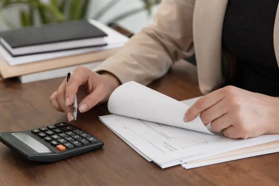 Of finance team member processing bills at a tidy office desk, shallow depth of field, realistic photo