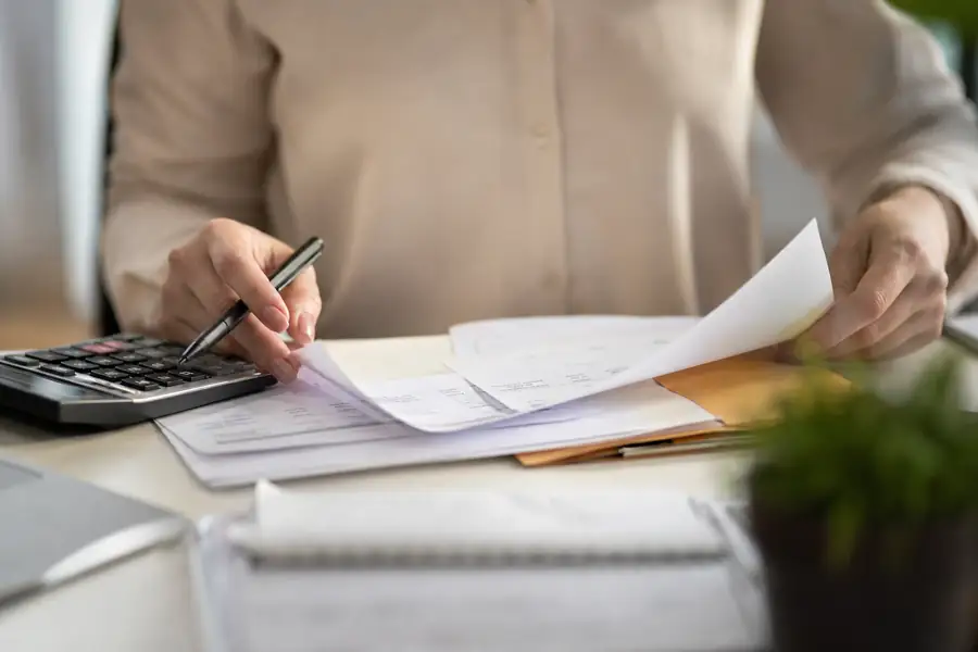 Finance team member processing bills at a tidy office desk