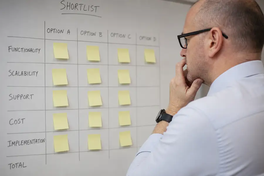Finance manager comparing software options on a whiteboard shortlist