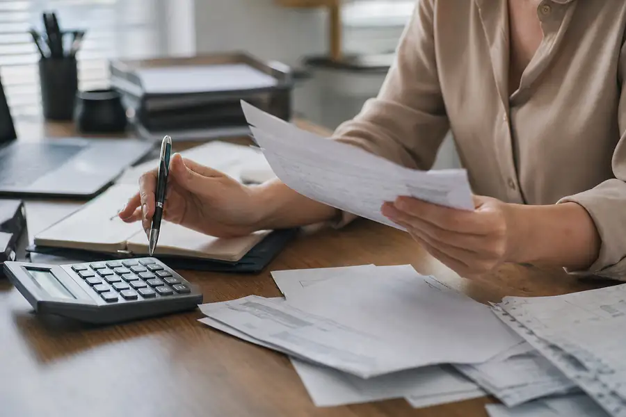 Finance team member processing bills at a tidy office desk