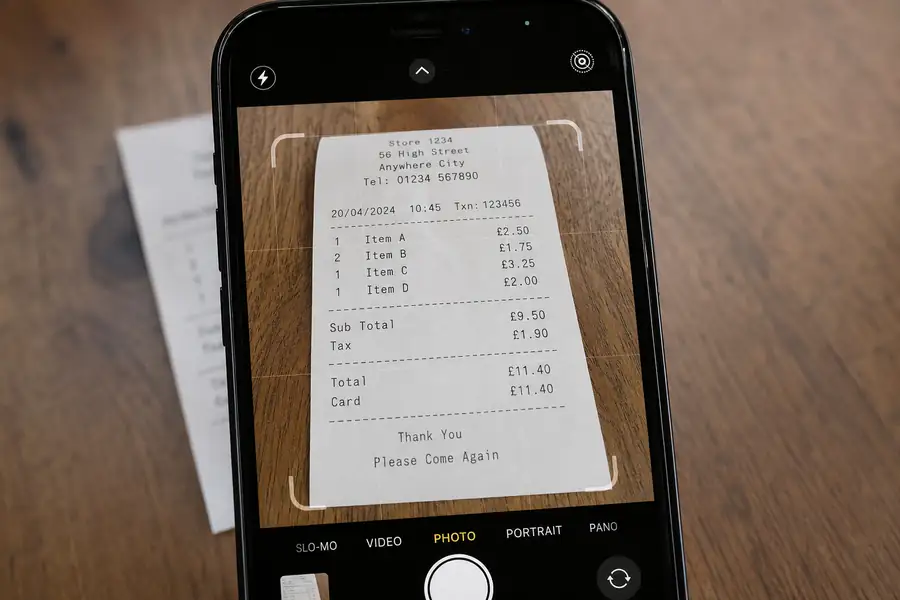 Phone camera capturing a receipt with an app interface overlay