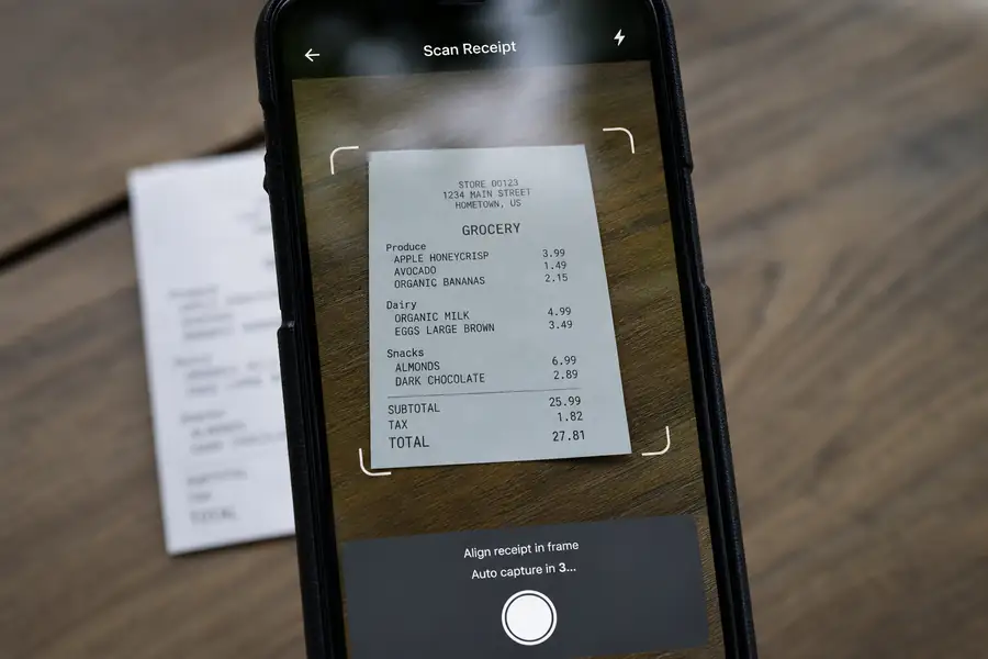Of phone camera capturing a receipt with an app interface overlay, shallow depth of field, realistic photo