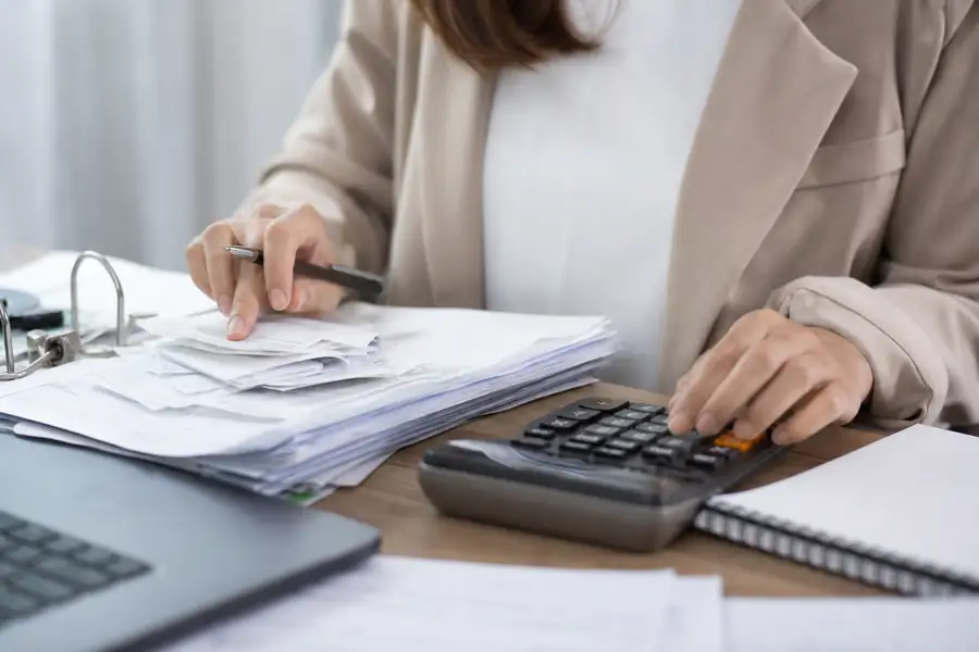 Of finance team member processing bills at a tidy office desk, shallow depth of field, realistic photo