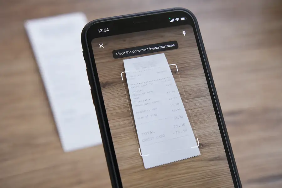 Of phone camera capturing a receipt with an app interface overlay, shallow depth of field, realistic photo